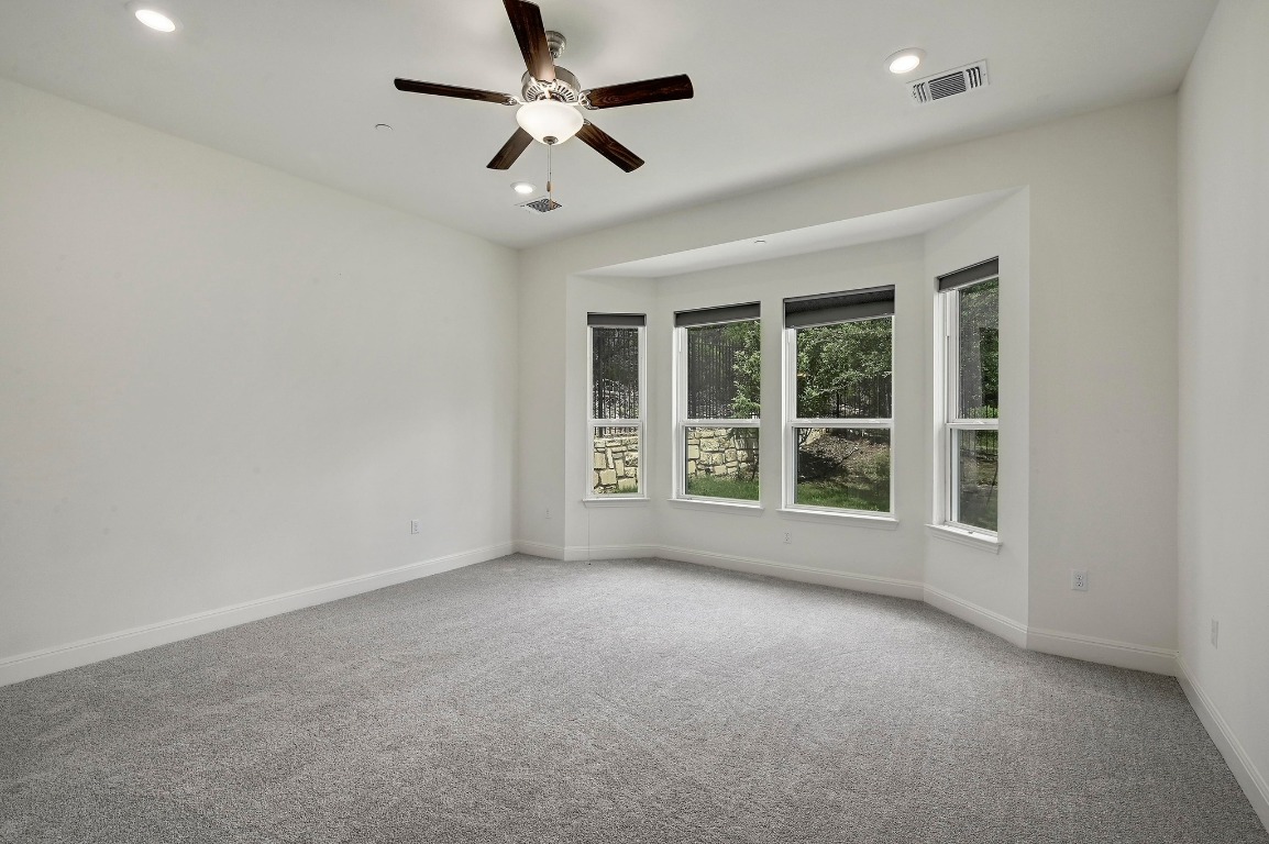 12308 Simmental Drive, Unit 94 Austin, TX 78732 - Photo 12 of 34 an empty room with a ceiling fan and windows