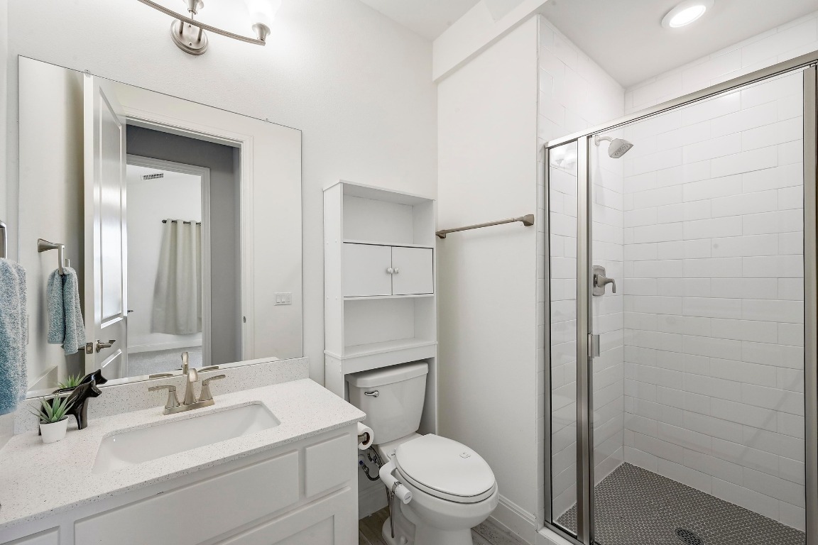 12308 Simmental Drive, Unit 94 Austin, TX 78732 - Photo 15 of 34 a bathroom with a sink a toilet a mirror and shower