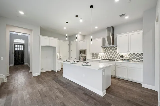 a kitchen with kitchen island sink stove and refrigerator