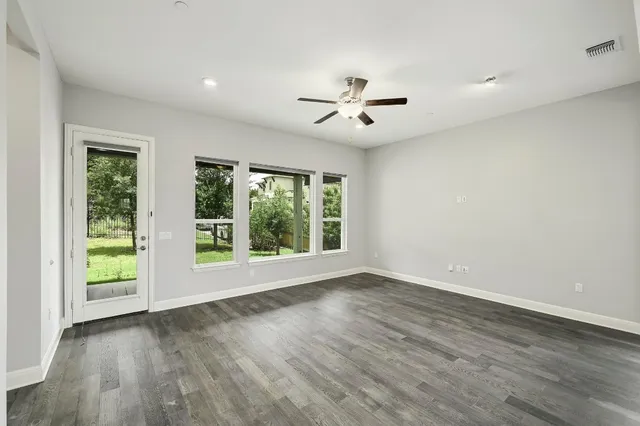a view of room with window ceiling fan and hardwood floor