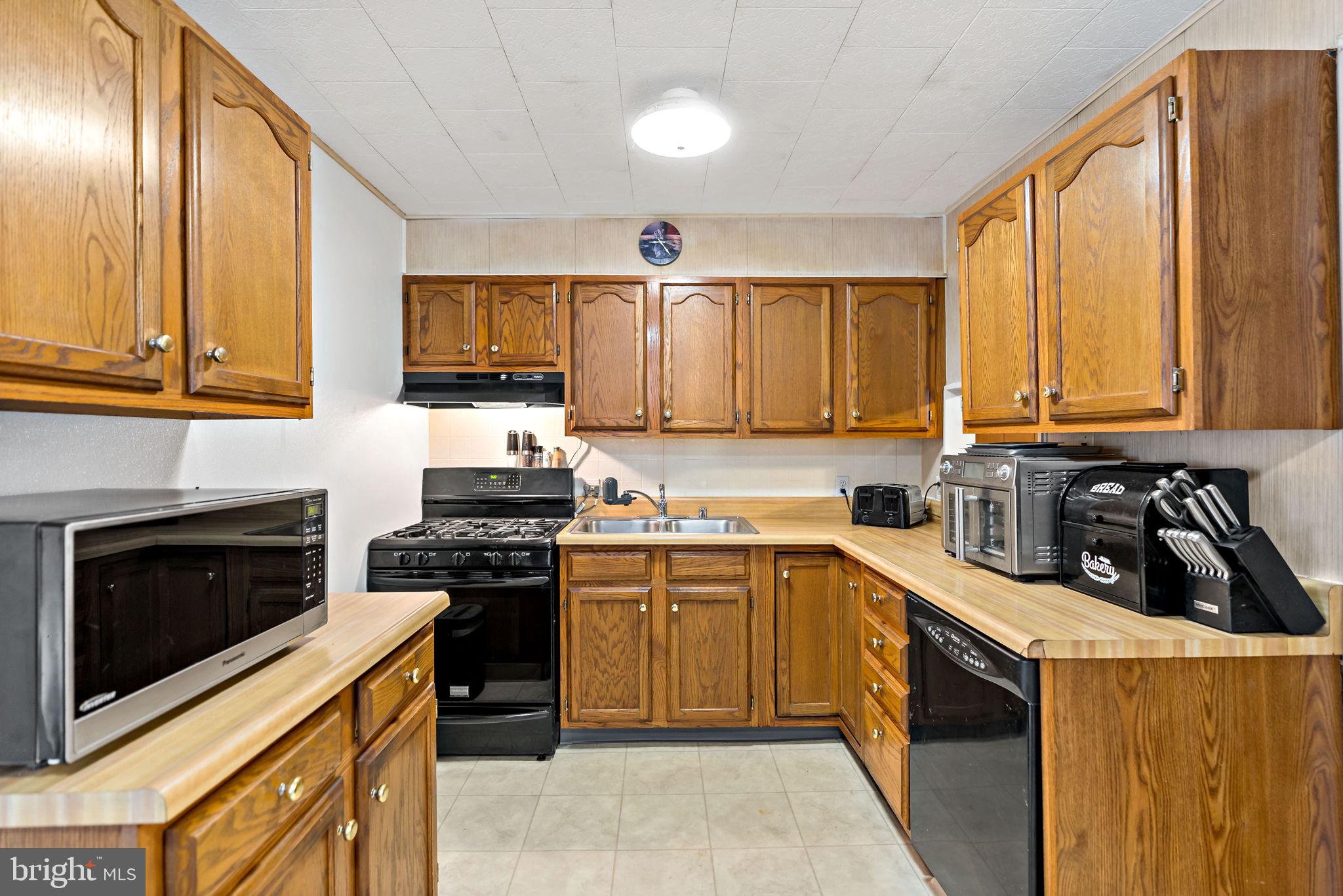 3421 Cornwall Road Dundalk, MD 21222 - Photo 19 of 45 a kitchen with stainless steel appliances granite countertop a stove sink microwave and cabinets
