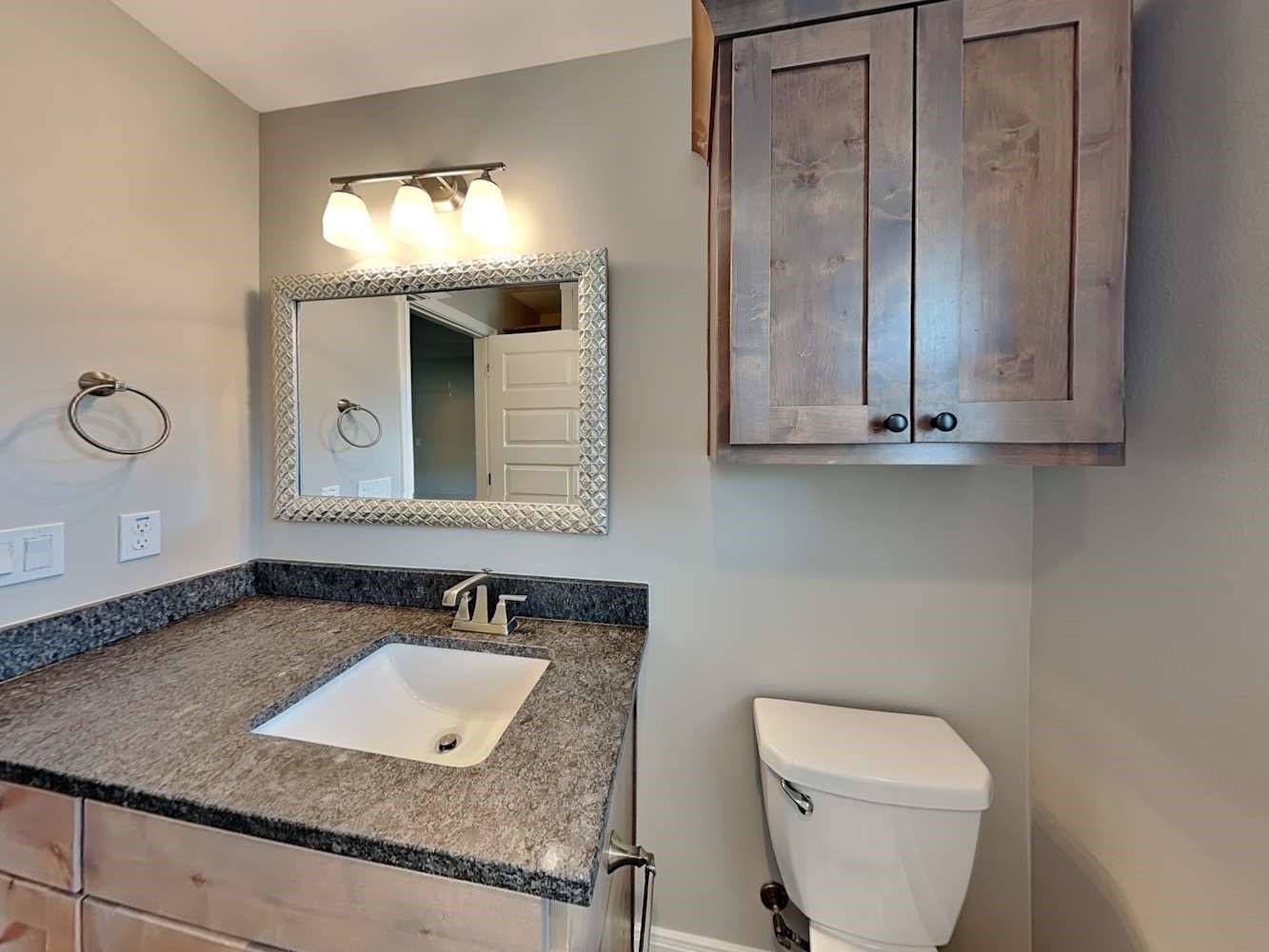 179 Holly Street, Unit 201 Georgetown, TX 78626 - Photo 16 of 17 a bathroom with a granite countertop sink and a toilet