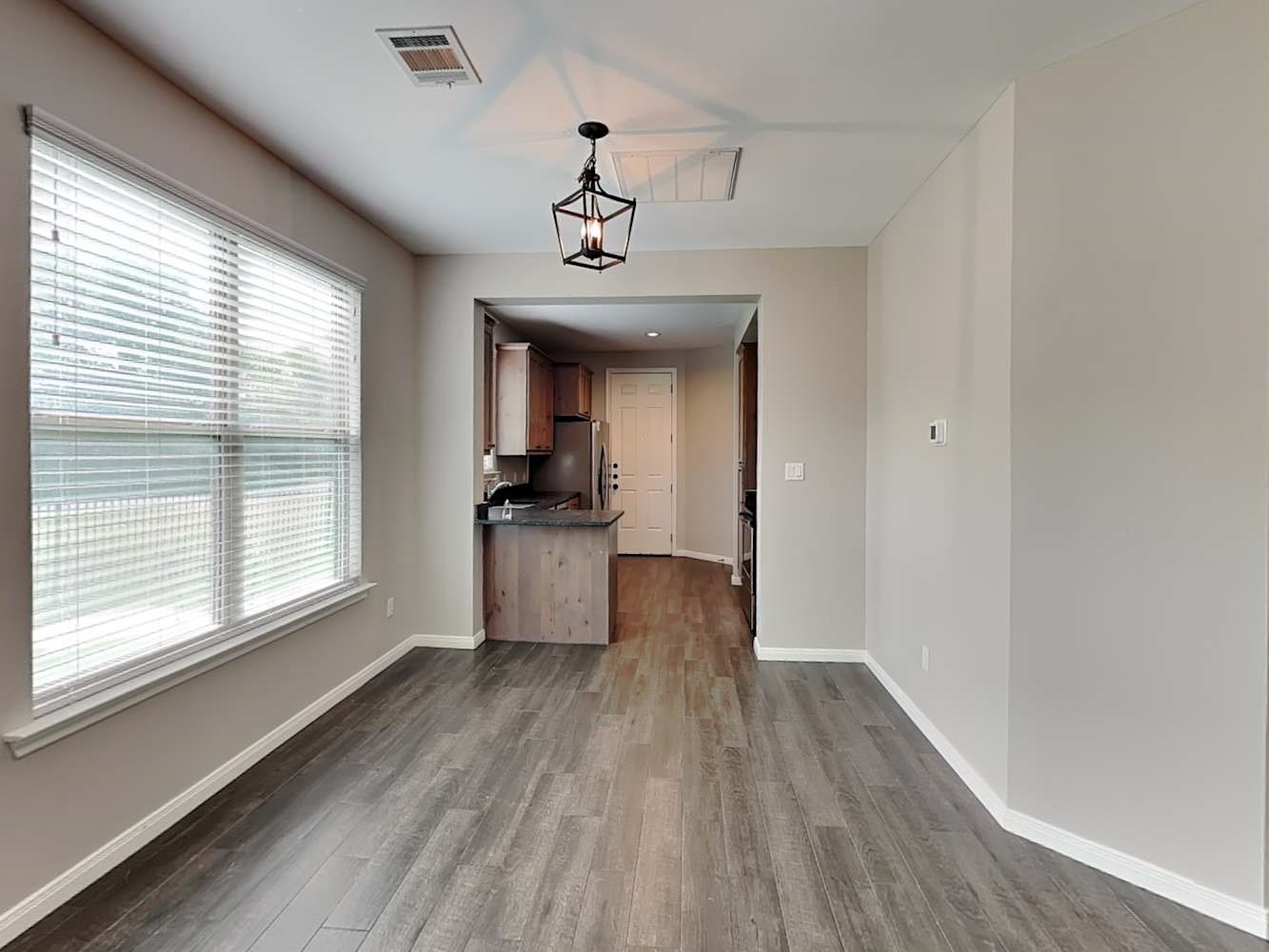 179 Holly Street, Unit 201 Georgetown, TX 78626 - Photo 6 of 17 a view of a hallway with wooden floor and a kitchen