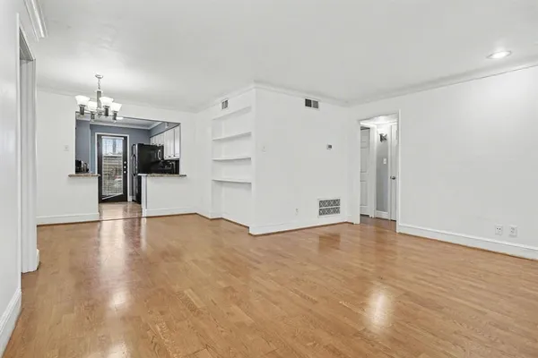 a view of a dining room with furniture a potted plant and wooden floor