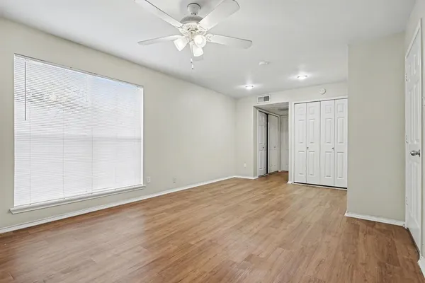 a spacious bedroom with a bed and a flat screen tv