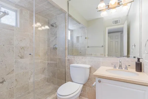 a bathroom with a granite countertop sink toilet and shower