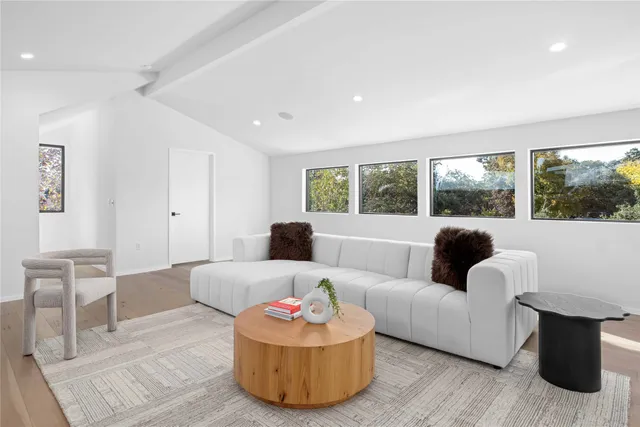 a view of a big room with wooden floor and windows