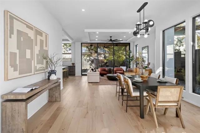 a dining room with wooden floor table and chairs