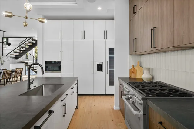 a kitchen with kitchen island a sink stove top oven and cabinets