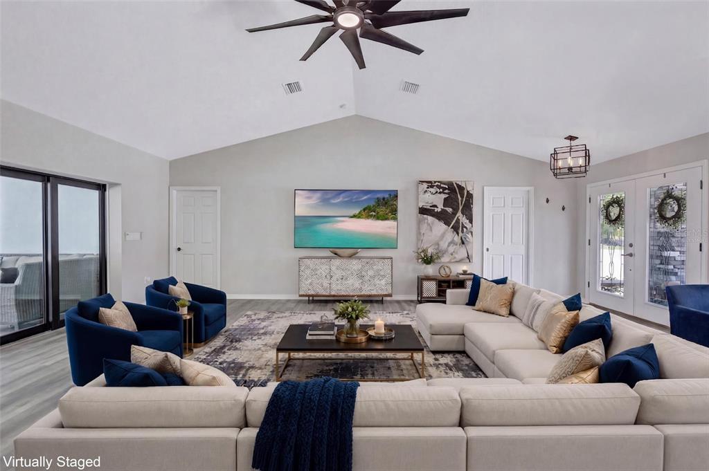13362 Downy Woodpecker Road Weeki Wachee, FL 34614 - Photo 5 of 26 a living room with furniture and a chandelier