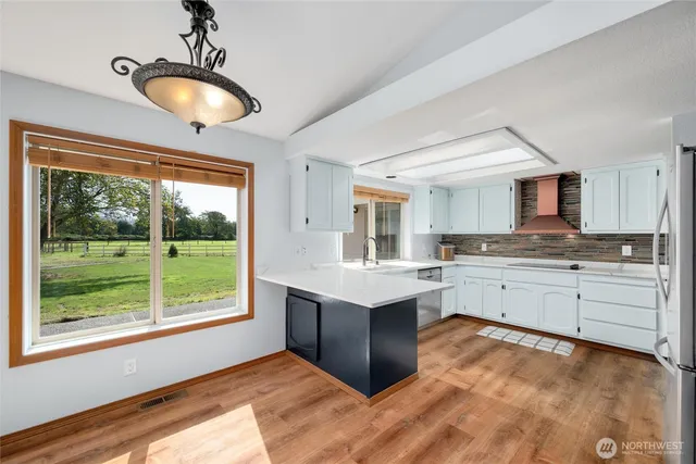 a kitchen with kitchen island granite countertop a stove and a sink