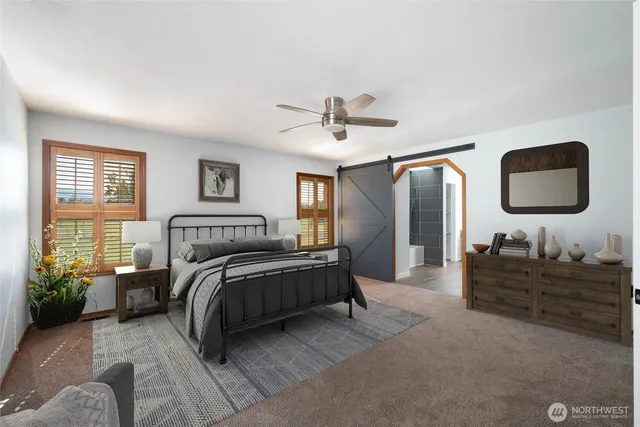 a spacious bedroom with a bed a lamp and window