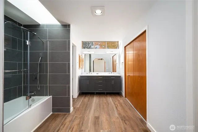a bathroom with a tub sink and mirror