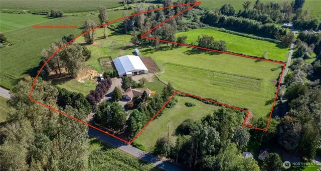 an aerial view of a house with a garden and lake view