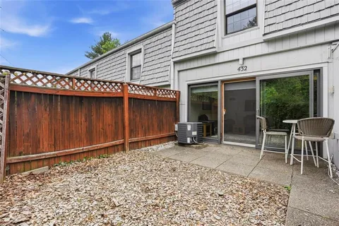 a view of a patio with table and chairs in front of house