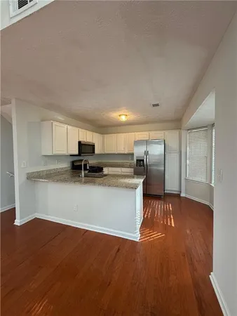 a view of a hallway with wooden floor and closet