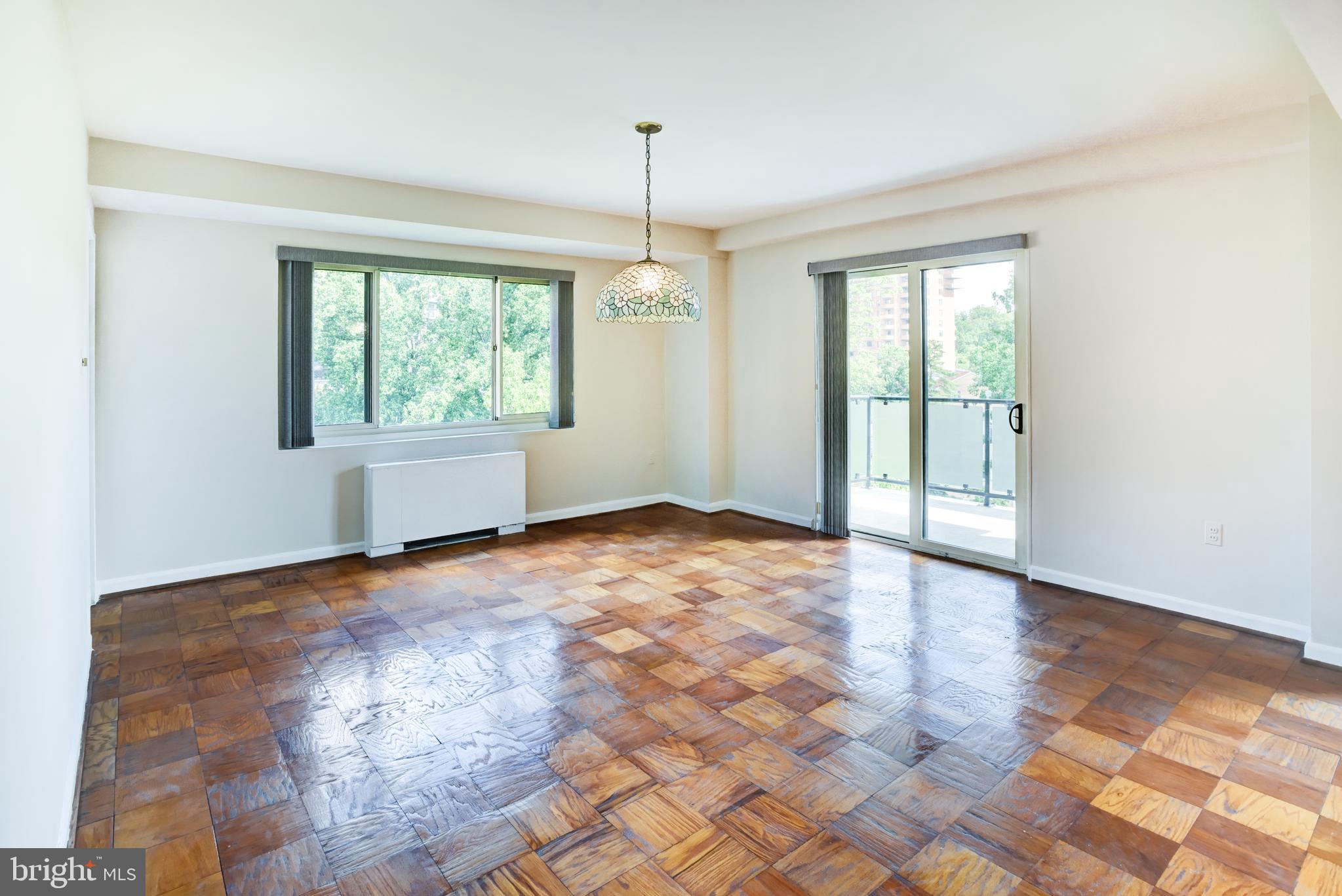 4201 Cathedral Avenue Northwest, Unit 1004E Washington, DC 20016 - Photo 15 of 69 a view of an empty room with wooden floor and a window