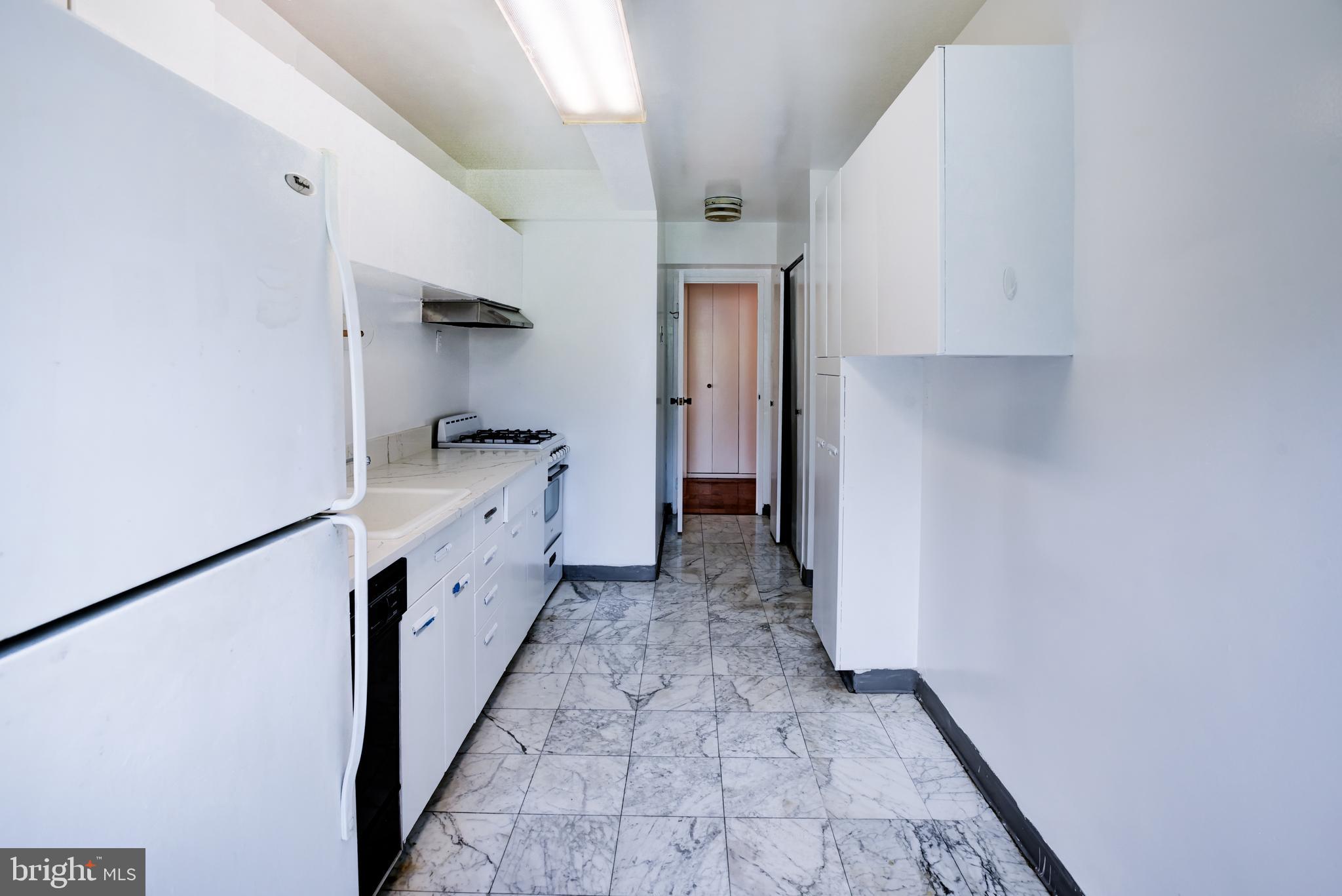 4201 Cathedral Avenue Northwest, Unit 1004E Washington, DC 20016 - Photo 22 of 69 a kitchen with white cabinets and a sink