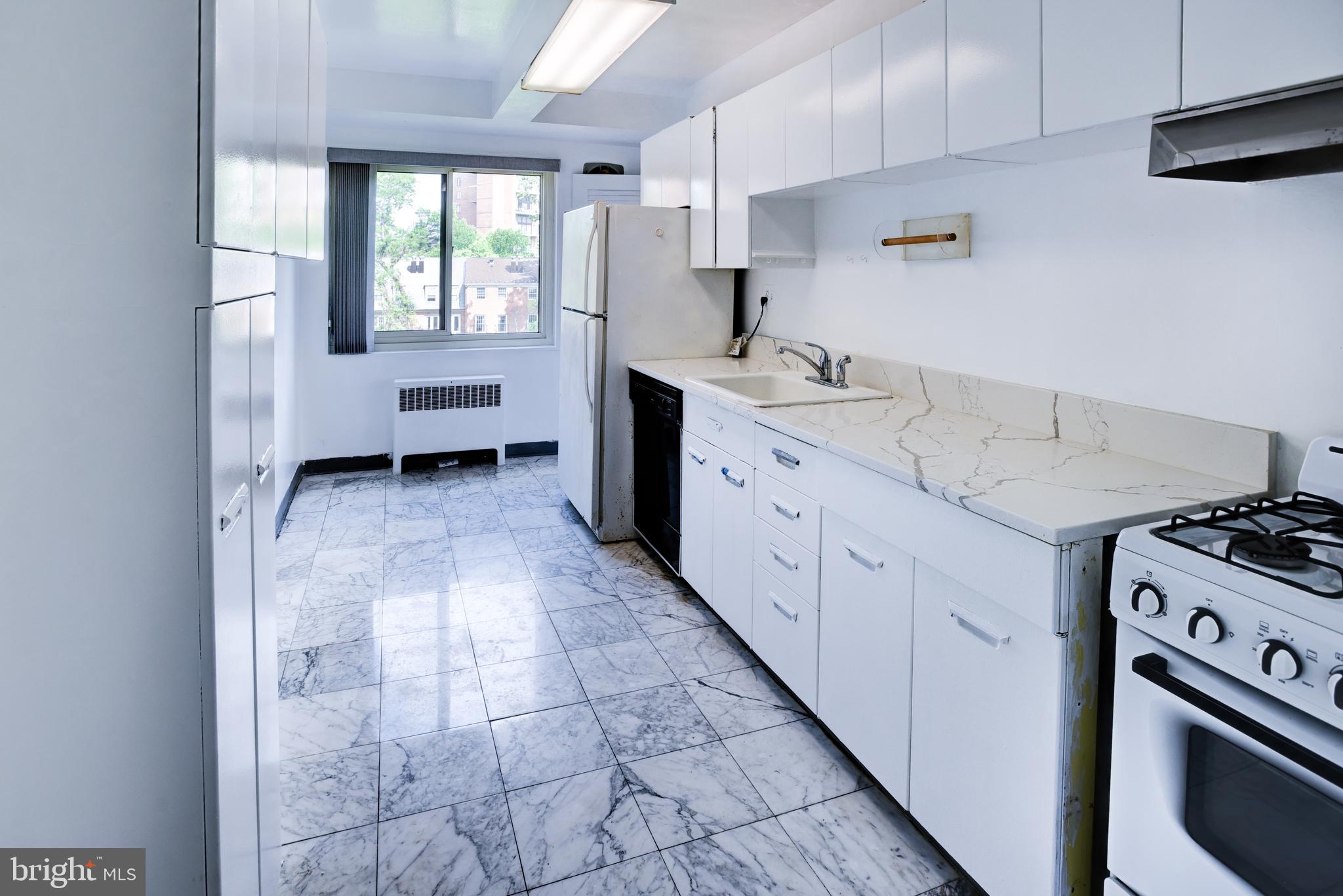 4201 Cathedral Avenue Northwest, Unit 1004E Washington, DC 20016 - Photo 26 of 69 a kitchen with a sink stove and cabinets