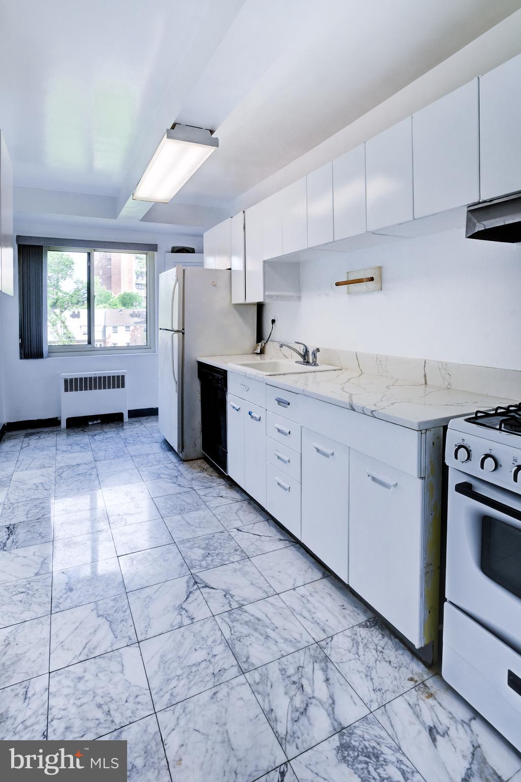 4201 Cathedral Avenue Northwest, Unit 1004E Washington, DC 20016 - Photo 27 of 69 a kitchen with stainless steel appliances a sink a stove a refrigerator and cabinets