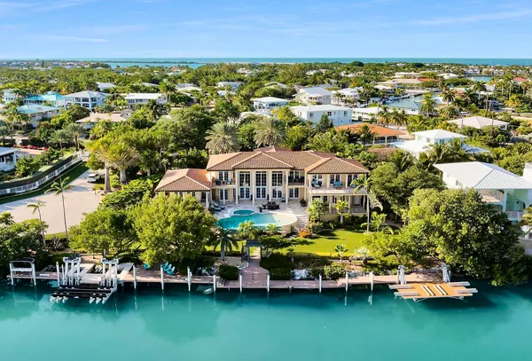 an aerial view of a house with a garden and lake view