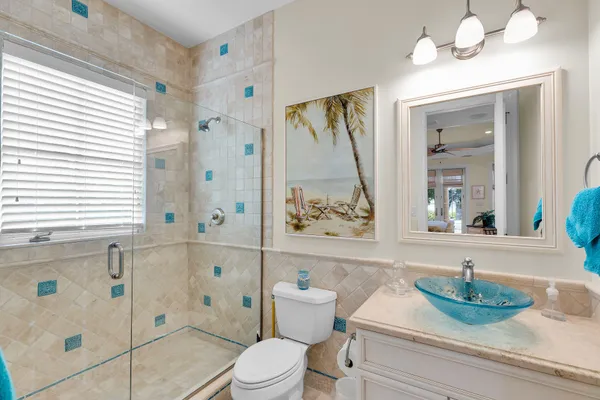a bathroom with a granite countertop sink vanity mirror and toilet