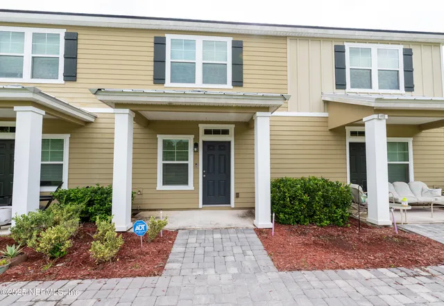 a view of a brick house with potted plants