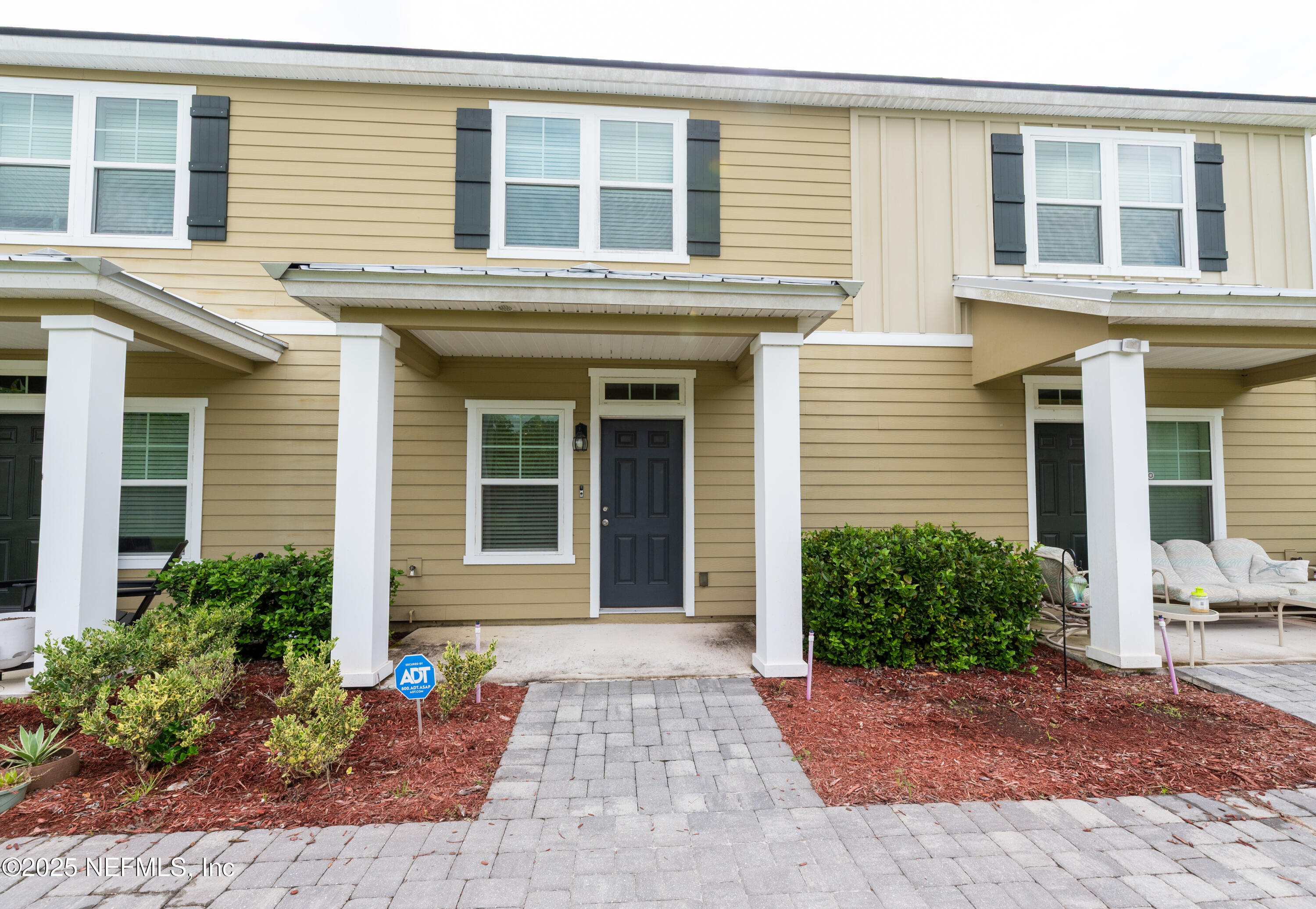 a view of a brick house with potted plants