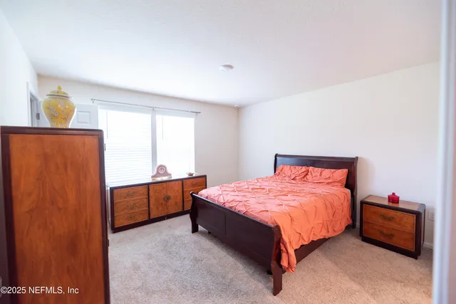 a bedroom with a bed and a refrigerator