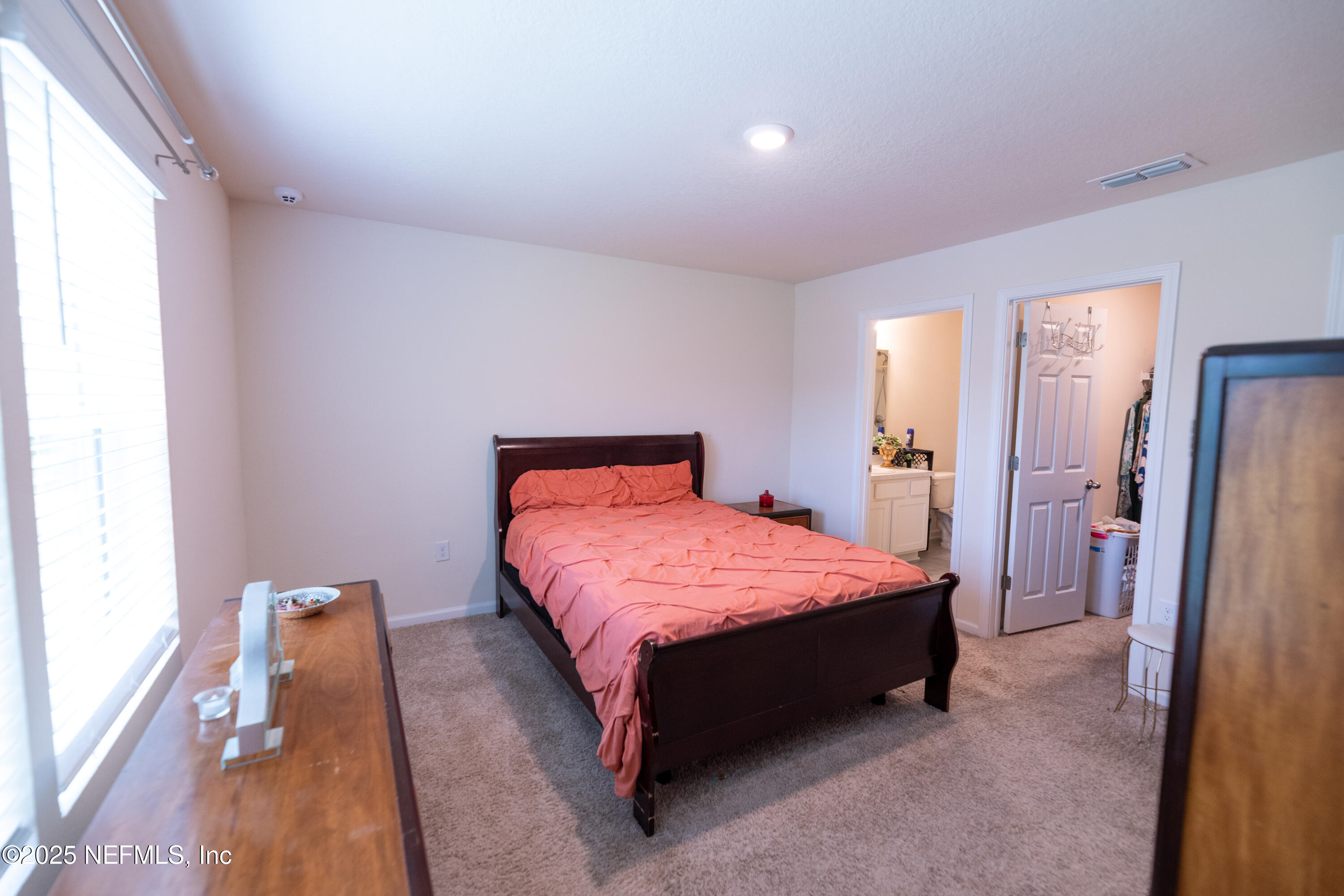 86990 Mainline Road Yulee, FL 32097 - Photo 14 of 17 a bedroom with a bed and a refrigerator