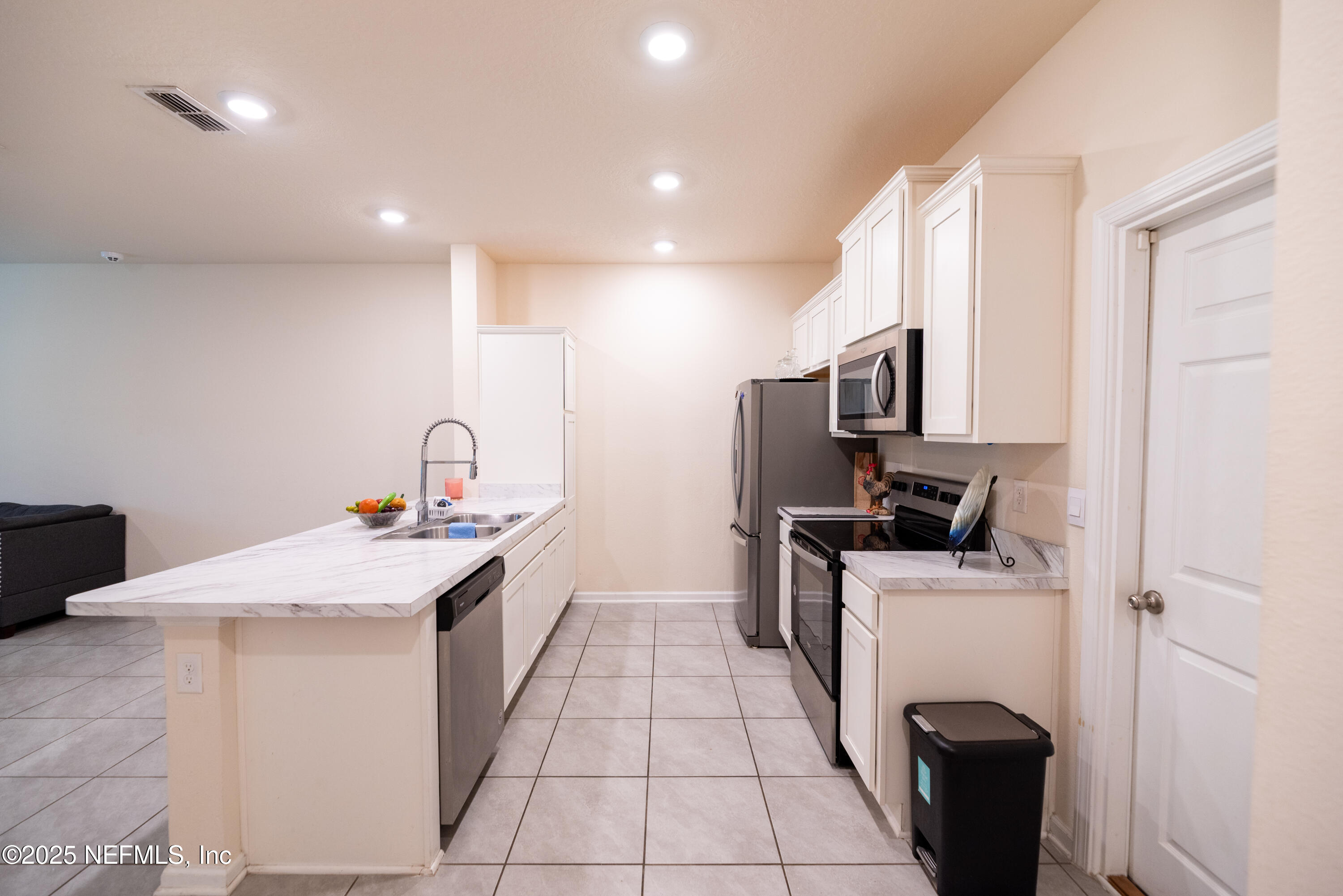86990 Mainline Road Yulee, FL 32097 - Photo 7 of 17 a kitchen with stainless steel appliances a sink a stove a refrigerator cabinets and a window