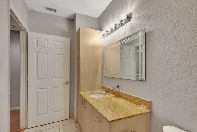 a bathroom with a granite countertop sink and a mirror