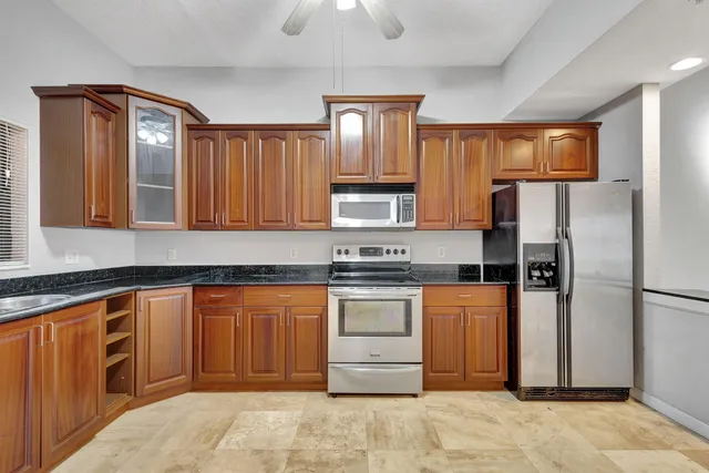 a kitchen with stainless steel appliances granite countertop a refrigerator and a sink