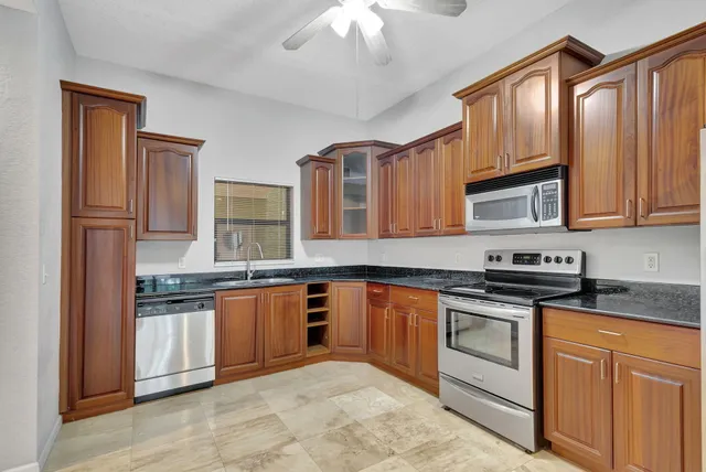 a kitchen with stainless steel appliances granite countertop a stove sink and cabinets