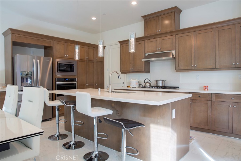 20800 Pine Cone Circle Porter Ranch, CA 91326 - Photo 13 of 43 a kitchen with a sink cabinets and stainless steel appliances