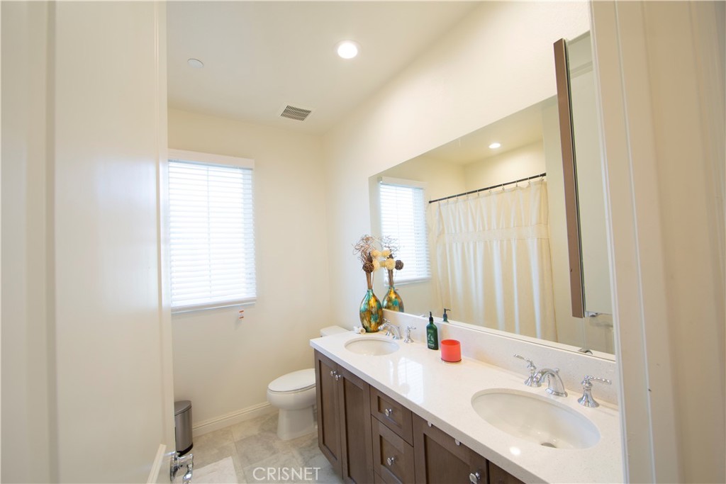 20800 Pine Cone Circle Porter Ranch, CA 91326 - Photo 23 of 43 a bathroom with a double vanity sink toilet and a mirror
