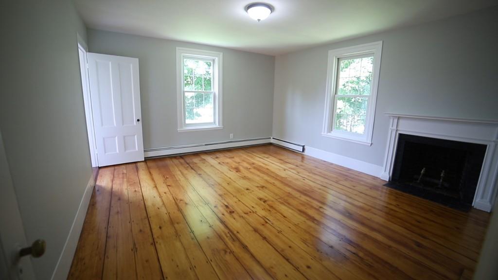 457 Edmands Road Framingham, MA 01701 - Photo 30 of 31 an empty room with wooden floor fireplace and windows