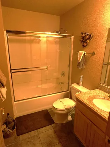 a bathroom with a granite countertop sink toilet and shower
