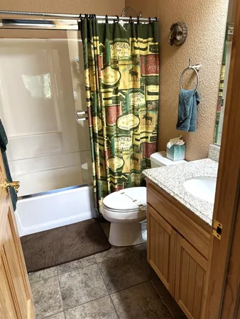 a bathroom with a granite countertop sink toilet and shower