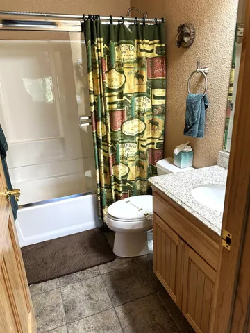a bathroom with a granite countertop sink toilet and shower