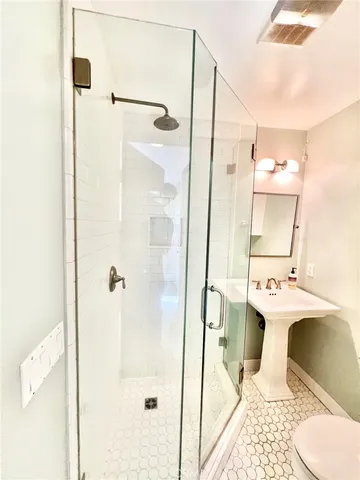 a bathroom with a sink and mirror with bathtub