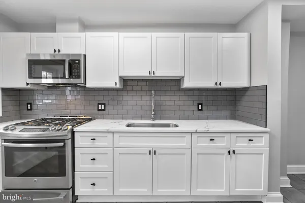 a kitchen with white cabinets and appliances