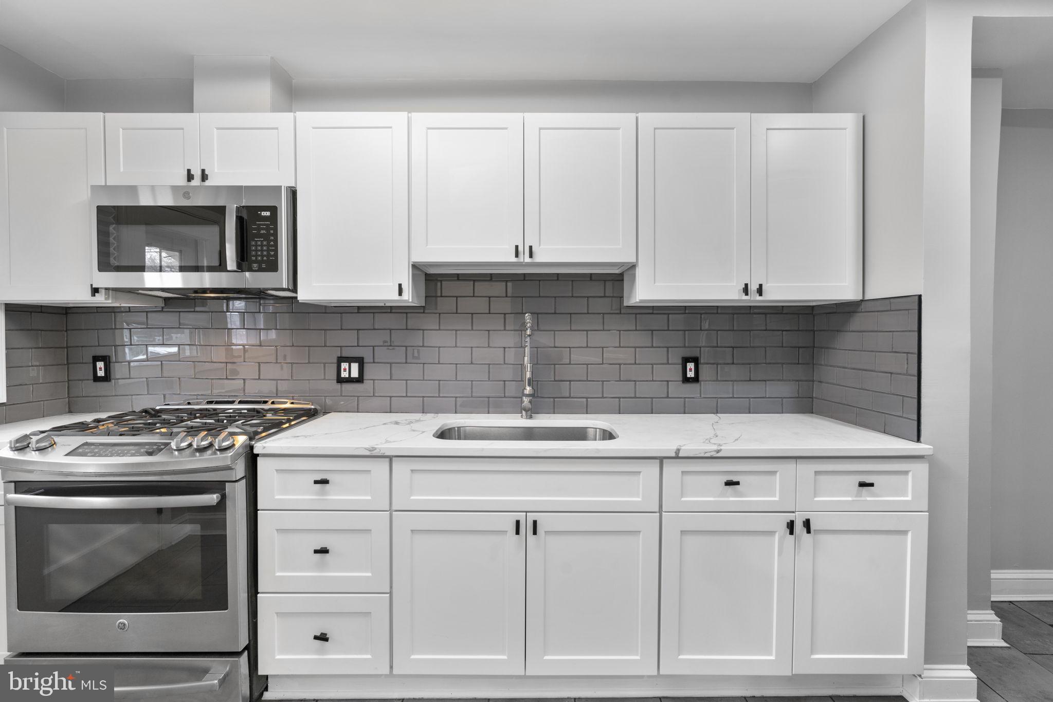 1607 Stonewood Road Baltimore, MD 21239 - Photo 11 of 53 a kitchen with white cabinets and appliances