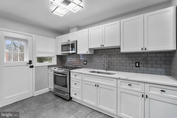 a kitchen with white cabinets stainless steel appliances and sink