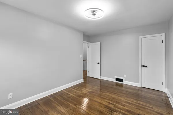 an empty room with wooden floor and window