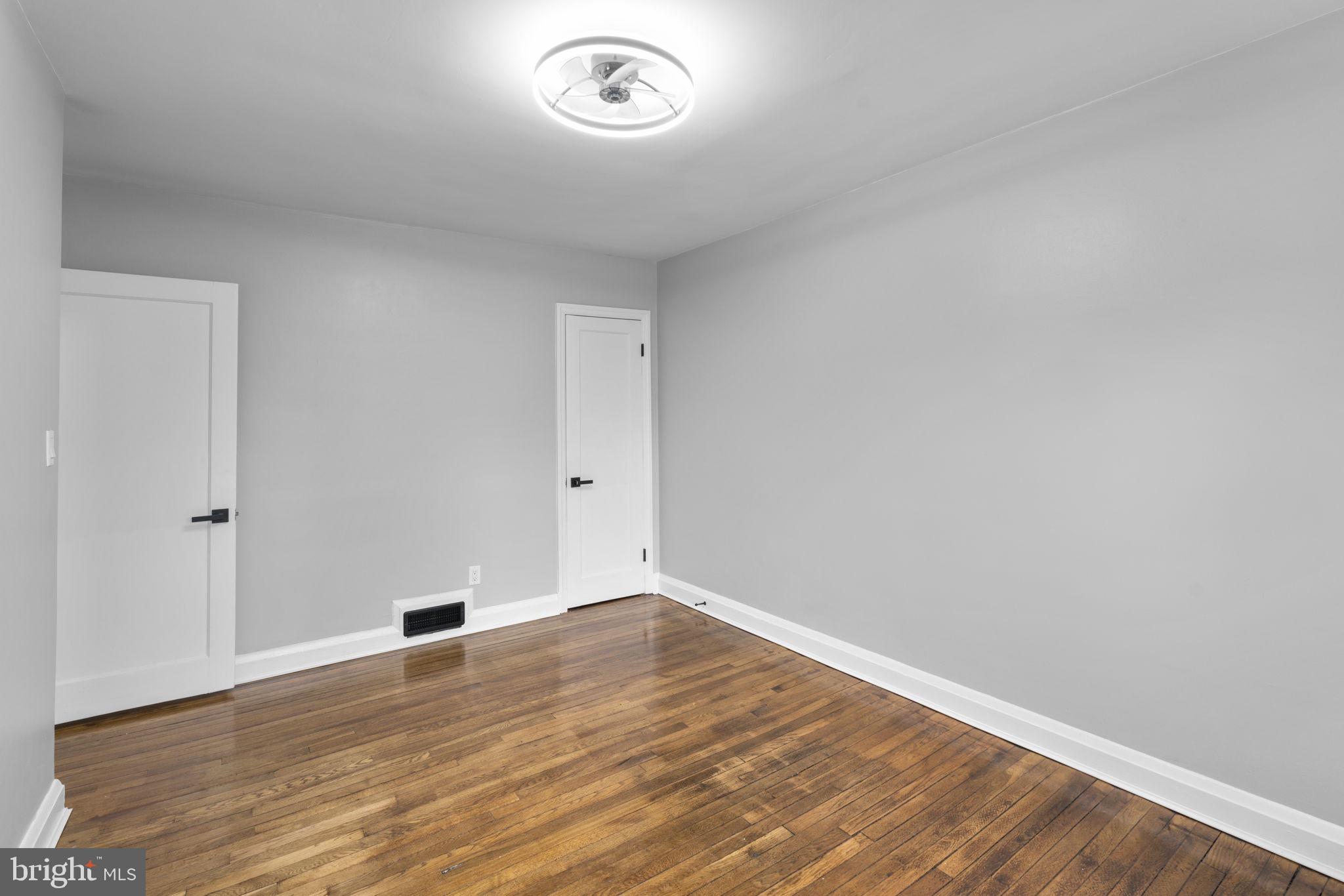 1607 Stonewood Road Baltimore, MD 21239 - Photo 23 of 53 an empty room with wooden floor and window