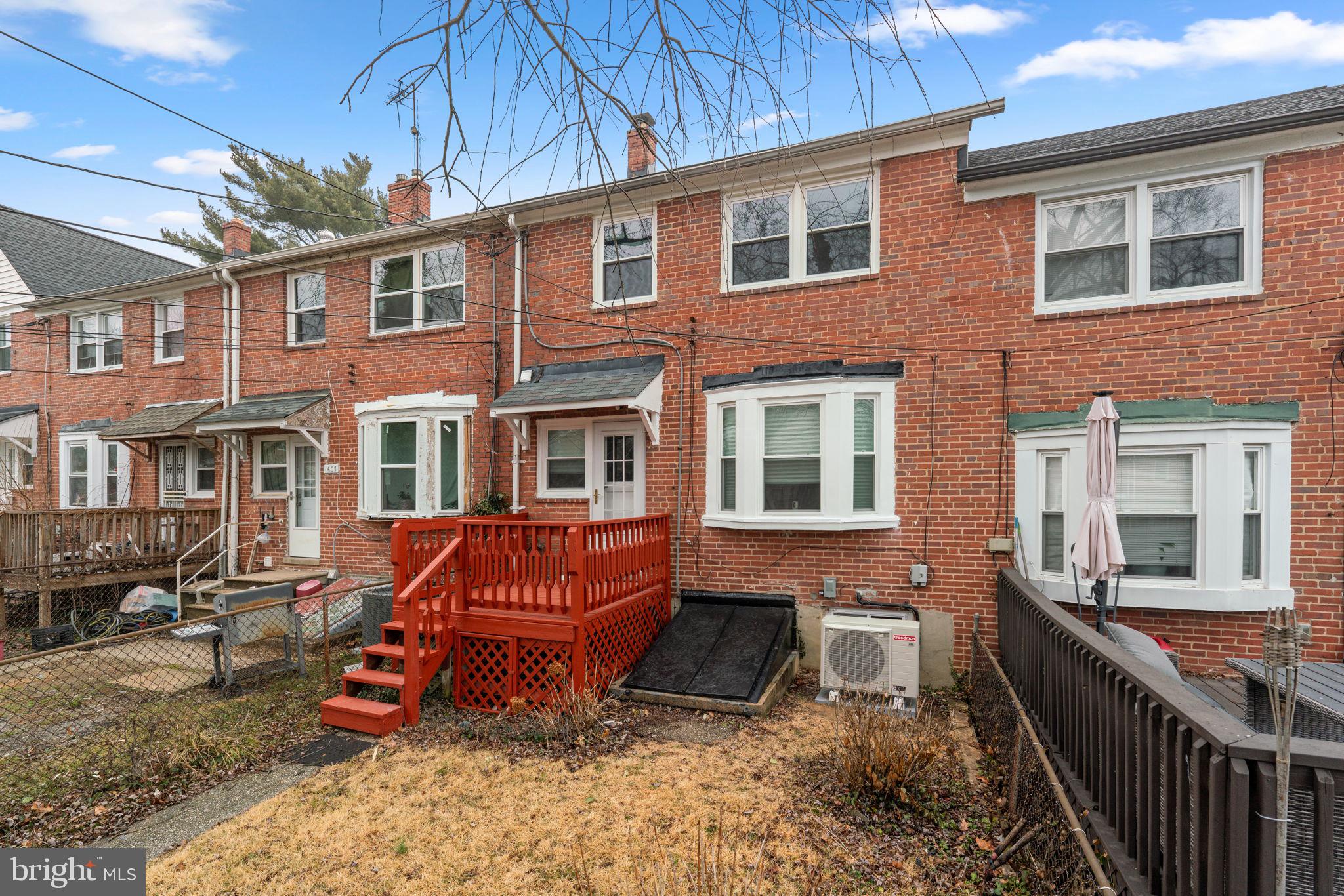 1607 Stonewood Road Baltimore, MD 21239 - Photo 43 of 53 a view of a brick house with large windows and a table