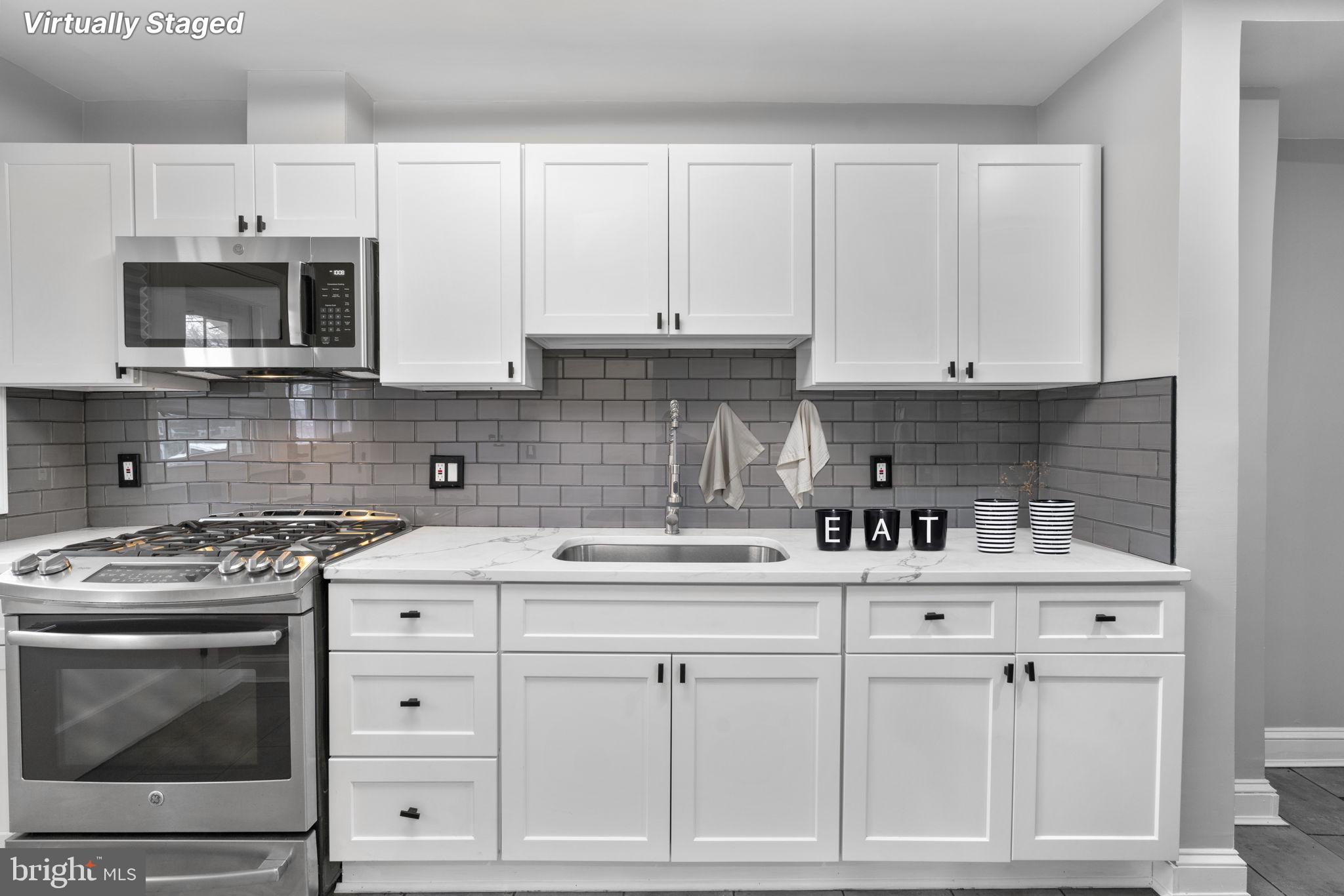 1607 Stonewood Road Baltimore, MD 21239 - Photo 44 of 53 a kitchen with white cabinets and appliances