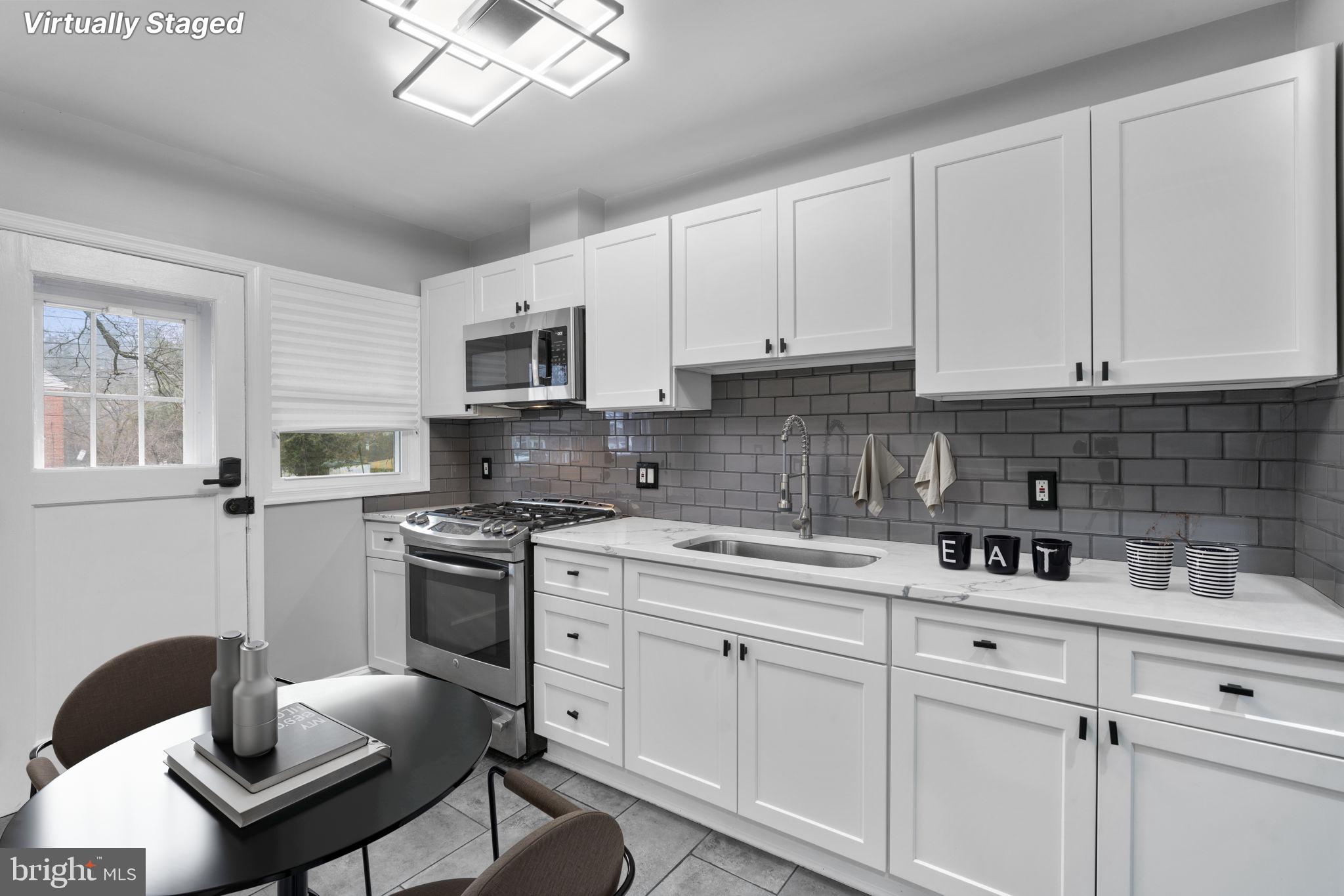 1607 Stonewood Road Baltimore, MD 21239 - Photo 45 of 53 a kitchen with a sink stove and white cabinets