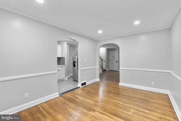 a view of a big room with wooden floor and windows